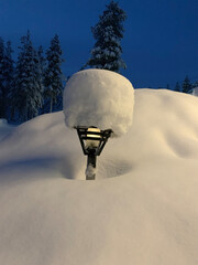 beautiful blurred winter landscape, thick layer of snow on lantern, trees, Levi ski resort,...