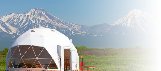 Glamping house in summer and volcano, rural landscape, tent houses in Kamchatka peninsula. Selective focus. © bborriss