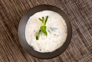 Pumpkin and carrot soup, tadka with cream and parsley . Top view.