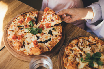 Closeup hands taking pizza pieces.