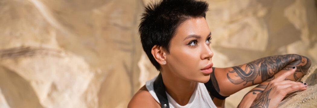 Portrait Of Young Brunette Archaeologist Looking Away Near Stone In Desert, Banner.