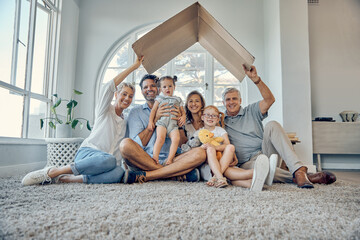 Big family, children and insurance with a mother, father and grandparents sitting under cardboard...