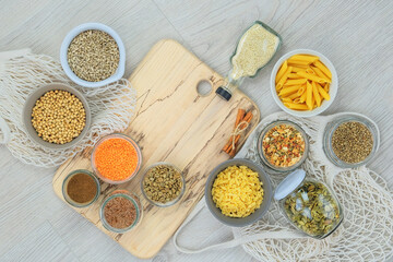 Organic bio products in zero waste shop. Various farm products in glass jars on a light wooden background. Copy space. Top view.