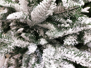 Artificial, diverse Christmas pine tree, snow, background.