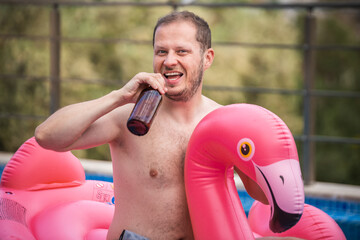 Cheerful man on flamingo rubber ring