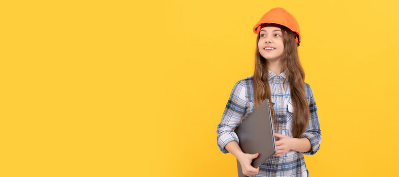 happy teen girl in helmet and checkered shirt holding computer, future career. Child in hard hat horizontal poster design. Banner header, copy space.