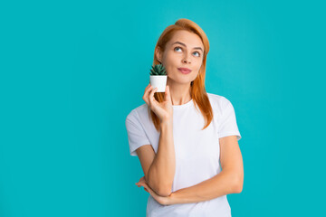 Care for potted cactus. Portrait of young woman holding flower pot with cactus.