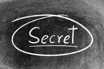 White chalk hand writing in word secret on blackboard background