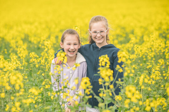 Two sisters standing in their family canola field