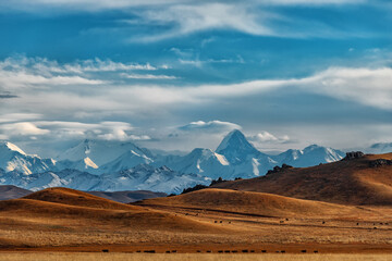 Northern Tien Shan mountain range with Khan Tengri peak in southeast Kazakhstan under a cloudy sky