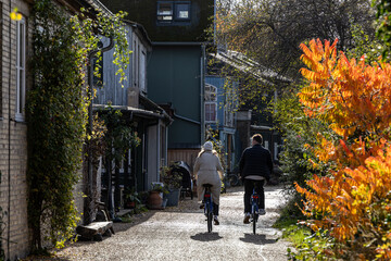 Copenhagen, Denmark, A young couple ride bikes through Christiania,