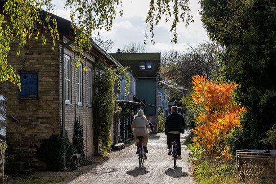 Copenhagen, Denmark, A young couple ride bikes through Christiania,
