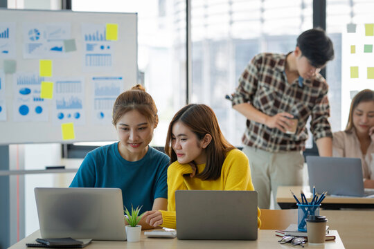 A group of young modern Asians is having a brainstorming meeting while sitting at work. Business meetings, planning, strategy, new business development online business ideas market competition.