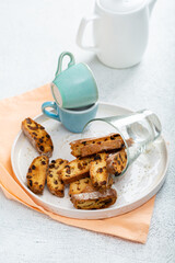 Close up of sweet cantuccini almond biscuits on plate copy space coffee cups pot