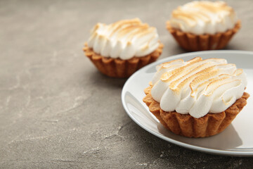 Appetizing lemon cupcakes with white cream on grey background. Holiday, surprise, birthday, Valentine's Day.