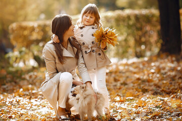 Naklejka na ściany i meble Cute and stylish family in a autumn park