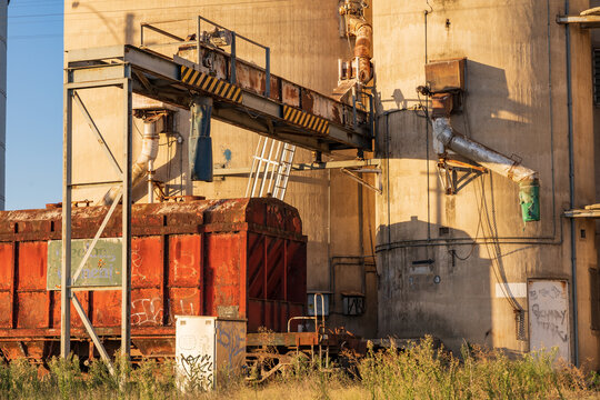 A railway grain carriage waiting alongside silos in a rural town
