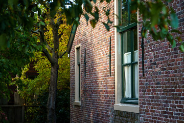 Fototapeta premium Side view of brick house with striking sunlight in authentic environment