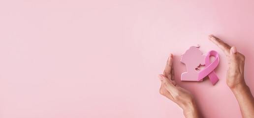 Hand hold protection pink ribbon and women symbol for Breast Cancer Awareness symbolic on pink background, protect and monitor breast cancer promote in October month campaign concept