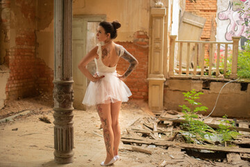 Portrait einer hübschen Ballerina, die in einem verstörten und verlassenen ballsaal Ballett tanzt
