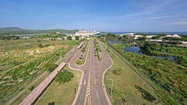 Road Leading To The Amber Cove Cruise Terminal On A Sunny Day In Maimon, Dominican Republic. - aerial FPV