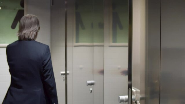 Business people use public restroom in office building. Realtime