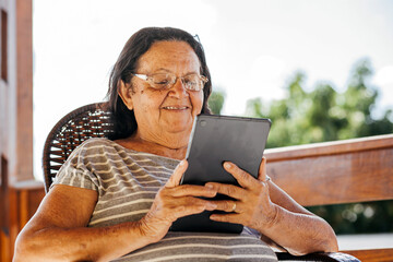 Brazilian senior woman using digital tablet at home