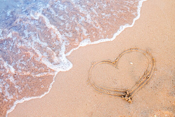 A wave that washes the heart painted on the sand. A memory of a happy holiday by the ocean.