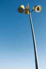 A street lamp standing against the blue sky.