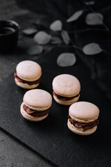 Caramel macarons with chocolate filling on black stone