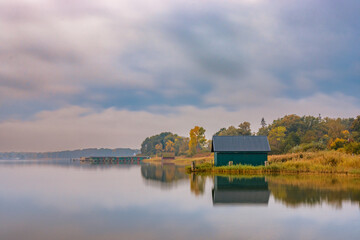 Einsame Bootshütte im Schilf am Plauer See in Mecklenburg-Vorpommern zu Sonnenaufgang im Herbst - obrazy, fototapety, plakaty