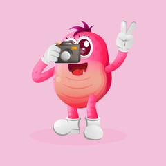 Cute pink monster taking photo with camera