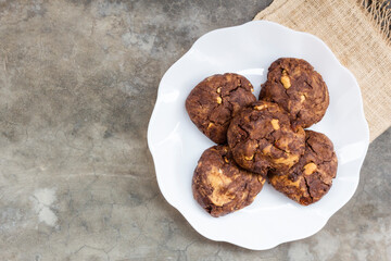 Chocolate cookies cashew nuts raisin in plate on stone table.