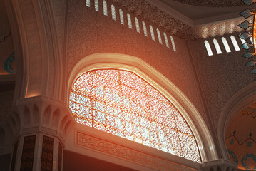 Stained glass window decorated in oriental style inside the mosque on a sunny day