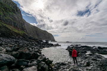 Dramatic picture of woman versus sea. Female thinking about adventure. Woman feeling small. Azores...