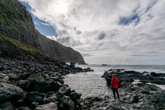 Dramatic picture of woman versus sea. Female thinking about adventure. Woman feeling small. Azores island, São Miguel. 