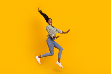 Fototapeta na wymiar Full length portrait of pretty cheerful girl jump have fun rejoice isolated on yellow color background