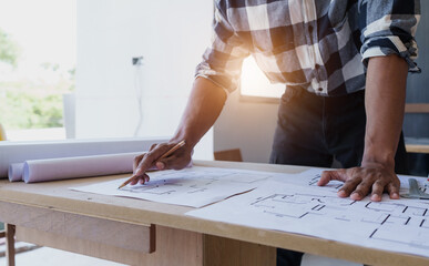 Successful home renovation, Architect engineer working with blueprints of house planning design and...