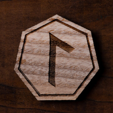 The runes are lying on a wooden table. Large rune Laguz