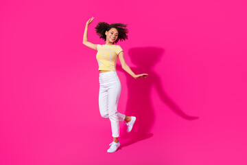Ful length photo of nice young woman dancing elegantly have fun dressed stylish yellow striped look isolated on vivid pink color background