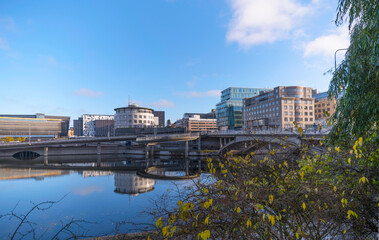 Arched walkway bridge, in the bay Klara Sjö skyscrapers, train yard and the north south connection road Klarastrandsleden, office and hotel buildings a sunny color full autumn day in Stockholm