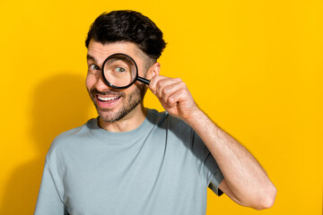 Photo of cheerful satisfied man stylish clothes using magnifying glass find investigation empty...