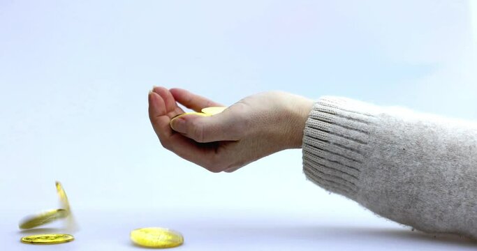 cryptocoins, Bitcoin or BTC being dropped in a woman's hand, depicting earning or paying with crypto or cryptocurrency and saving, holding or hodling. High quality 4k footage