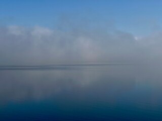 Lake river in early morning with fog and reflection