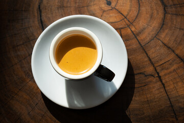 A cup of espresso on a wooden table. top view