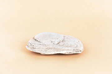 Stone podium for product presentation and branding on a pastel beige background. 