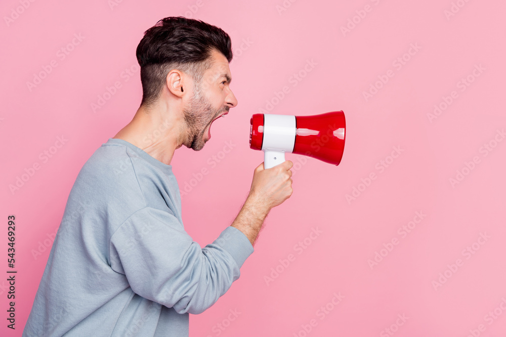 Canvas Prints Side profile photo of young funny stressed angry guy hold microphone scream loud look empty space bad mood isolated on pink color background