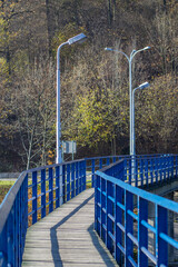 Most nad rzeką z niebieskimi barierkami - obrazy, fototapety, plakaty