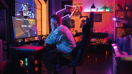 Gaming at Home: Gamer Frustrated and Angry After Losing a Round of Playing Online Video Game on Personal Computer. Stylish Male Playing Shooter Online Multiplayer PvP Battle. Creative Living Room. © Gorodenkoff