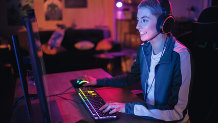 Professional eSports Female Gamer Plays RPG Strategy Video Game with Lots of Action and Fun on Her Powerful Personal Computer at Home. Cyber Gaming Stylish Retro Neon Room. © Gorodenkoff